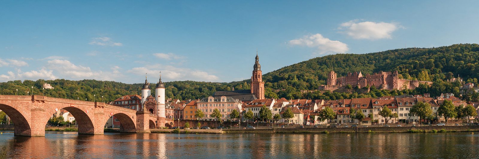 Heidelberg an einem sonnigen Tag: Alte Brücke, Altstadt mit Heiliggeistkirche und das Schloss am Königstuhl über dem Neckar